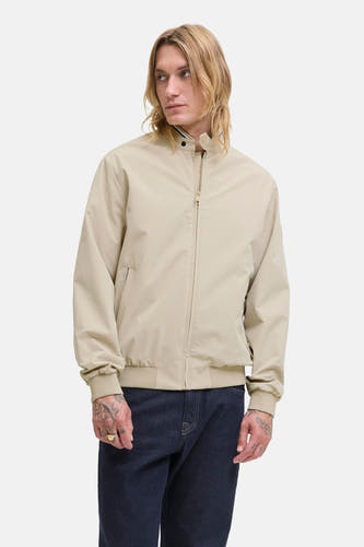 Manteau court beige d'ORIGINALS BY JACK & JONES, avec fermeture éclair et porté avec un jean foncé.
