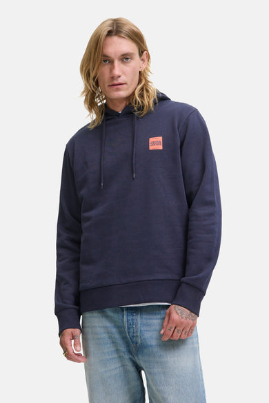Pull-over bleu avec capuche d'ORIGINALS BY JACK & JONES, avec patch de logo orange et jeans bleu clair.