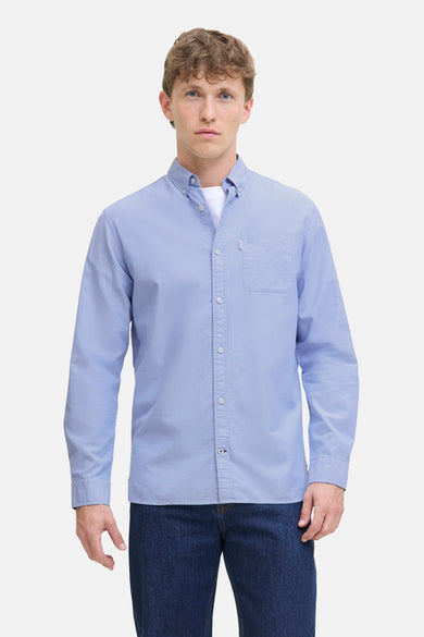 Chemise bleue à manches longues de PREMIUM by JACK & JONES, avec poche poitrine et portée sur un T-shirt blanc.