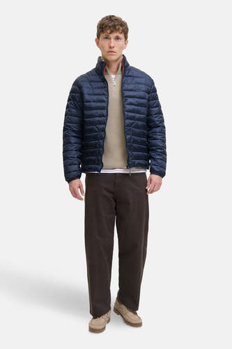 Manteau bleu court de PREMIUM BLUE par JACK & JONES, avec fermeture éclair et porté sur une chemise beige et un pantalon marron.