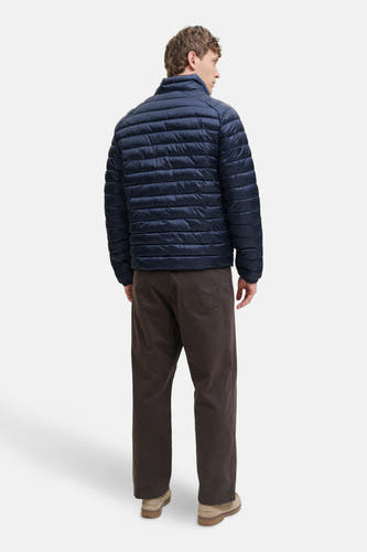 Manteau court bleu de PREMIUM BLUE par JACK & JONES, avec des coutures horizontales, porté avec un pantalon marron et des chaussures en suède.