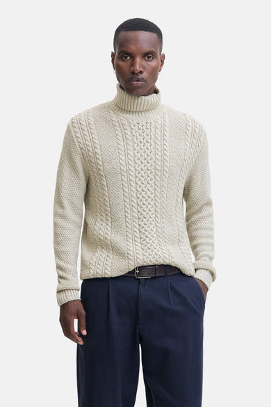 Pull beige à col montant de PREMIUM BLUE par JACK & JONES, avec un motif côtelé et porté avec un pantalon marine et des chaussures marron.
