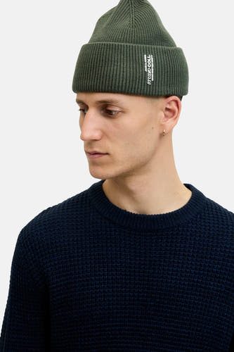 Chapeau vert de ACCESSORIES BY JACK & JONES, porté avec un pull bleu foncé et une boucle d'oreille dorée.