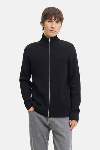 Gilet noir de CORE BY JACK & JONES, avec fermeture à glissière et jeans gris.