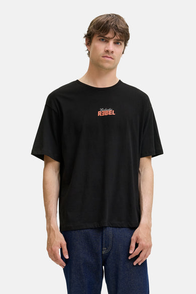 T-shirt noir à manches courtes de JJREBEL, avec une impression textuelle sur la poitrine et porté avec un jeans foncé.