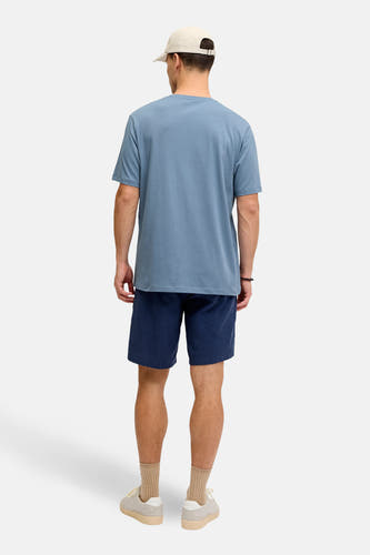 T-shirt bleu à manches courtes de JJREBEL, vu de dos avec des shorts bleus foncés, des chaussettes et des baskets.