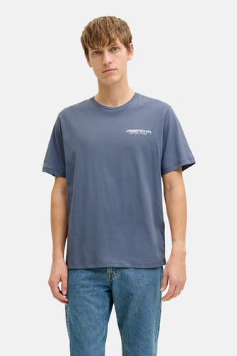 T-shirt bleu à manches courtes de JJREBEL, porté avec un jean et des baskets blanches à semelles brunes.