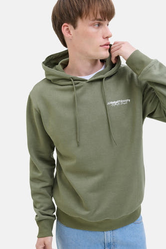 Sweater vert avec capuche JJREBEL, avec impression blanche et cordons, porté sur un t-shirt blanc.
