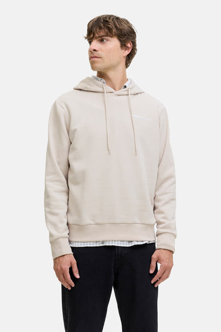 Gilet écru avec capuche JJREBEL, porté sur une chemise à carreaux et des jeans noirs.
