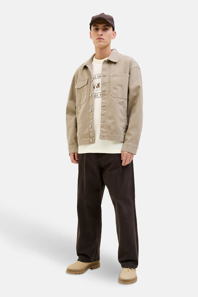 Ecru T-shirt met korte mouwen van ORIGINALS BY JACK & JONES, gedragen onder een beige jas, met een donkere broek en beige schoenen.
