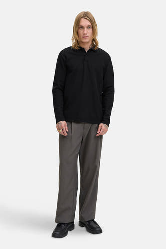 T-shirt V-hals noir de PREMIUM BLUE par JACK & JONES, avec des manches longues, associé à un pantalon gris et des chaussures noires.