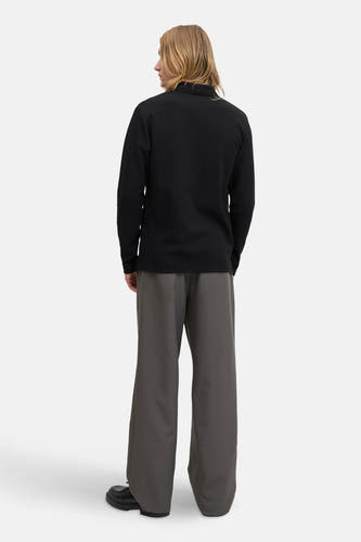 Pull noir à col V de PREMIUM BLUE par JACK & JONES, vu de dos, associé à un pantalon gris et des chaussures noires.