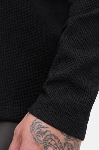 Pull-over noir à col V de PREMIUM BLUE par JACK & JONES, avec une texture côtelée et une tattoo visible sur la main.