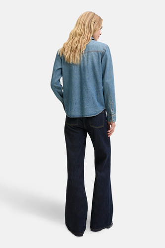 Jean flare bleu marine de JJXX, vu de de derrière, avec une blouse en denim.