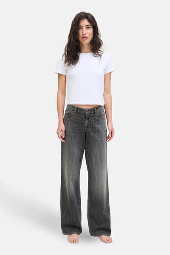 Jean droit en denim gris foncé de JJXX, associé à un T-shirt blanc et pieds nus.