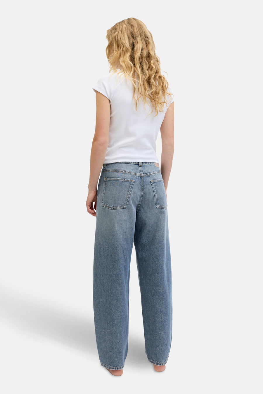 Jean en denim bleu spécial fit de JJXX, vu de l'arrière, avec un T-shirt blanc.