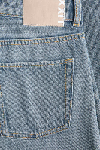 Jean en denim bleu moyen de JJXX, avec une poche arrière et une étiquette en cuir sur la ceinture.
