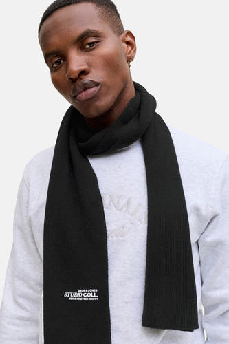Chapeau d'hiver noir d'ACCESSORIES BY JACK & JONES, avec un détail de logo en bas, porté avec un pull gris.