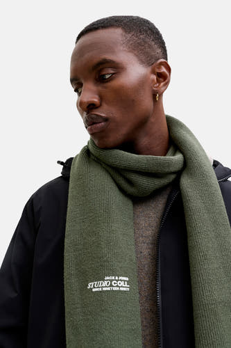 Manteau d'hiver vert par ACCESSORIES BY JACK & JONES, avec logo de marque, porté avec une veste noire et un pull marron.