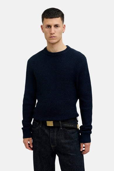 Ceinture noire d'ACCESSORIES BY JACK & JONES, avec une boucle dorée, portée avec un jean foncé.