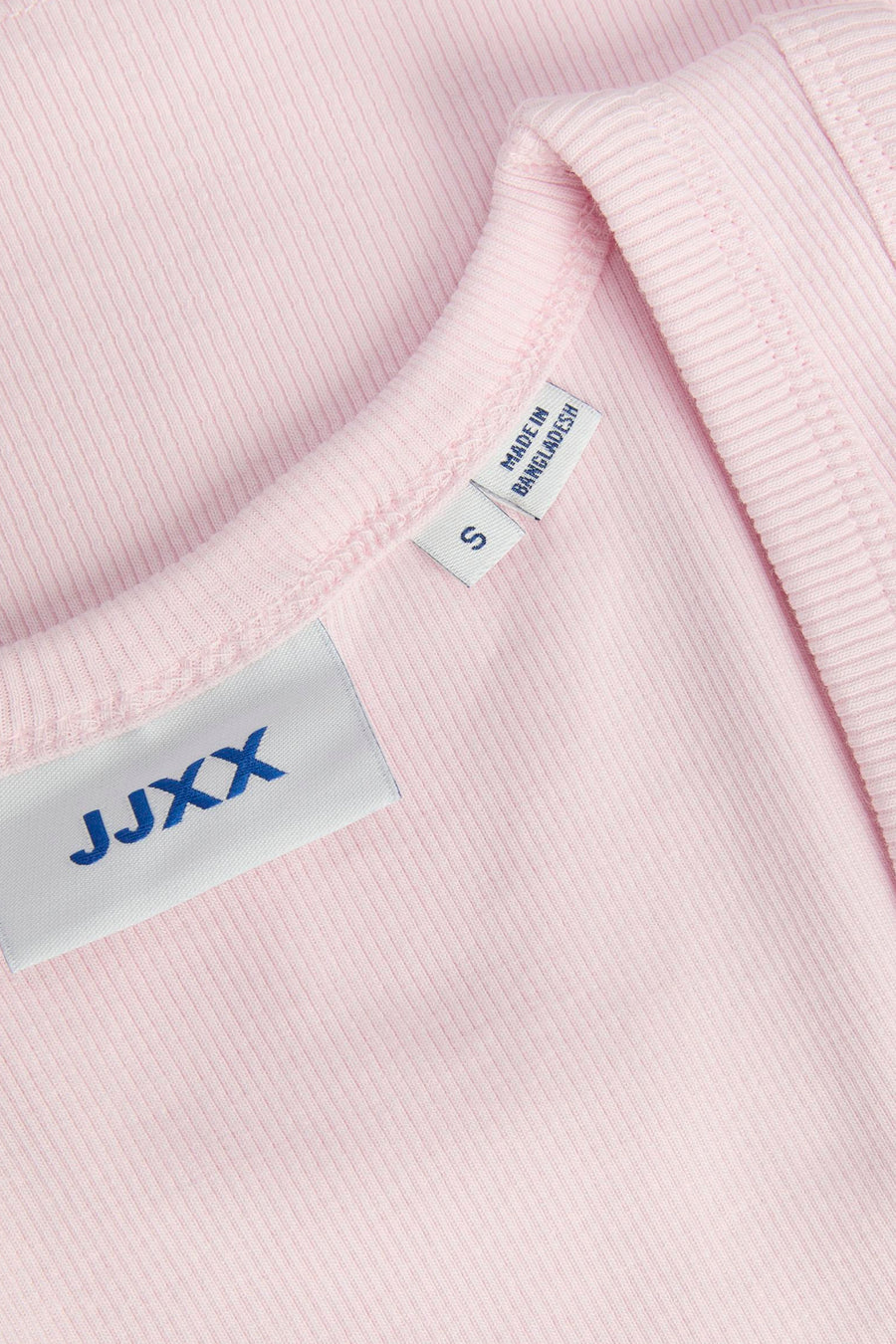 Haut côtelée rose de JJXX, gros plan de l'encolure avec étiquette de taille S et 'Made in Bangladesh'.
