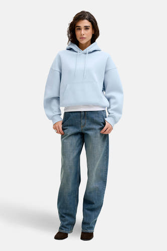 Blauwe sweater met kap van JJXX, gedragen met een wit T-shirt en wijde jeans.