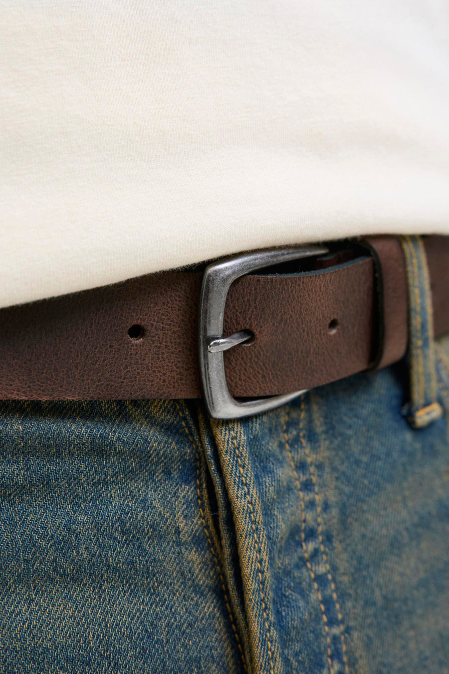 Ceinture brune de ACCESSORIES BY JACK & JONES, portée avec un pantalon en denim et une chemise blanche.