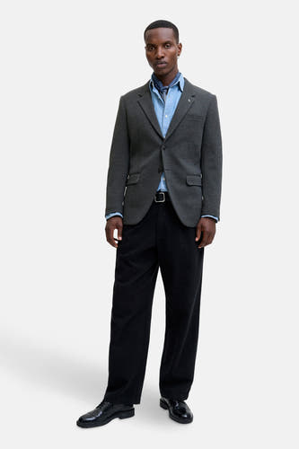Blazer gris de PREMIUM par JACK & JONES, porté avec un chemisier bleu et un pantalon noir.