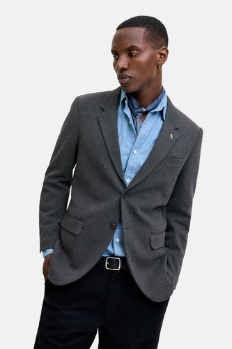 Blazer gris de PREMIUM par JACK & JONES, avec une subtile texture, associé à un chemisier bleu et un bandana.
