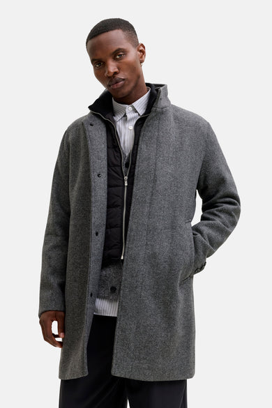 Long manteau gris de PREMIUM par JACK & JONES, avec un motif à carreaux, porté sur une veste en duvet et un chemisier rayé.