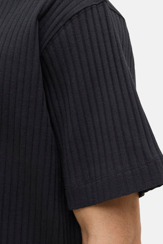 T-shirt noir à manches courtes de CORE BY JACK & JONES, avec une texture côtelée verticale et un bord de manche visible.