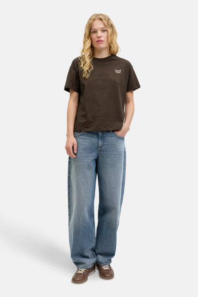 T-shirt brun à manches courtes de JJXX, avec logo texte et associé à des jeans larges.