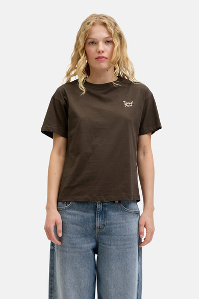 T-shirt brun à manches courtes de JJXX, avec une impression de texte 'Tasty & Fresh' en blanc, associé à des jeans larges.