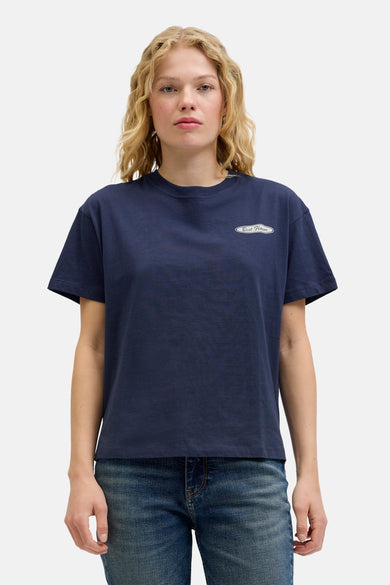 T-shirt bleu à manches courtes de JJXX, avec un petit logo 'Best Flavor' et porté avec un jean.