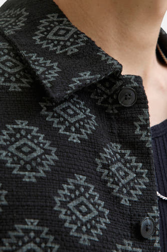 Chemise noire à manches longues de CORE BY JACK & JONES, avec un motif géométrique et une fermeture à boutons.