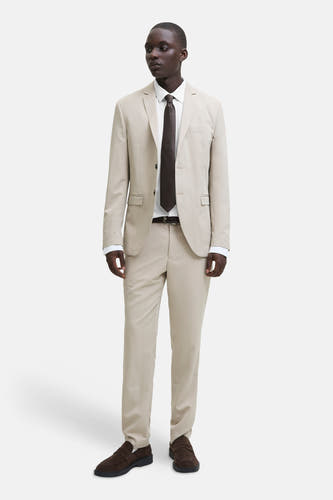 Chemise blanche de PREMIUM by JACK & JONES, à manches longues et col classique, portée sous un costume beige.