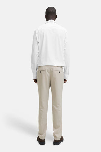 Chemise blanche à manches longues de PREMIUM by JACK & JONES, vue de dos, associée à un pantalon beige et des chaussures marron.