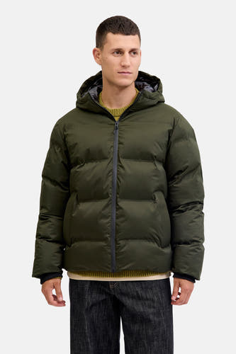 Manteau vert court de CORE BY JACK & JONES, avec capuche, porté sur un pull vert et des jeans foncés.