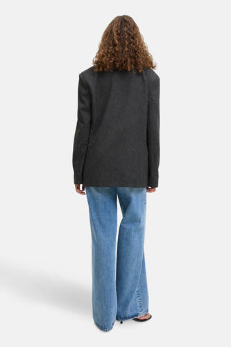 Blazer gris de JJXX, avec des manches longues et porté sur des jeans bleus clairs larges.