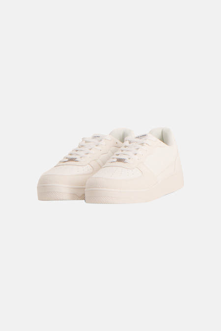 Baskets blanches d'ACCESSORIES BY JACK & JONES, avec des accents en daim et une semelle plate, en vue de côté.