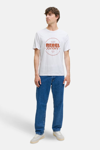 T-shirt blanc à manches courtes de JJREBEL, avec une impression inspirée des vintage sur l'avant, porté avec des jeans et des baskets.