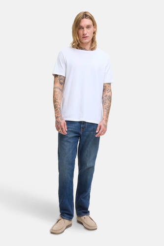 Jean tapered bleu marine de JACK & JONES JEANS INTELLIGENCE, associé à un T-shirt blanc et des chaussures en cuir de mouton.