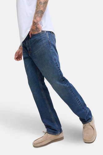 Jean tapered en denim bleu foncé de JACK & JONES JEANS INTELLIGENCE, porté avec des chaussures en cuir casual.