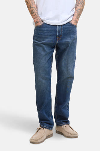 Jean tapered en denim bleu marine de JACK & JONES JEANS INTELLIGENCE, porté avec des chaussures de cuir beige.
