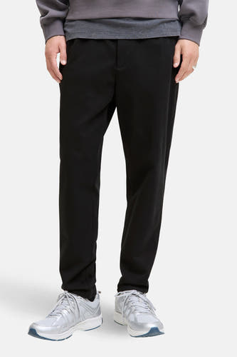 Pantalon noir de JACK & JONES JEANS INTELLIGENCE, avec pull gris et baskets argentées.