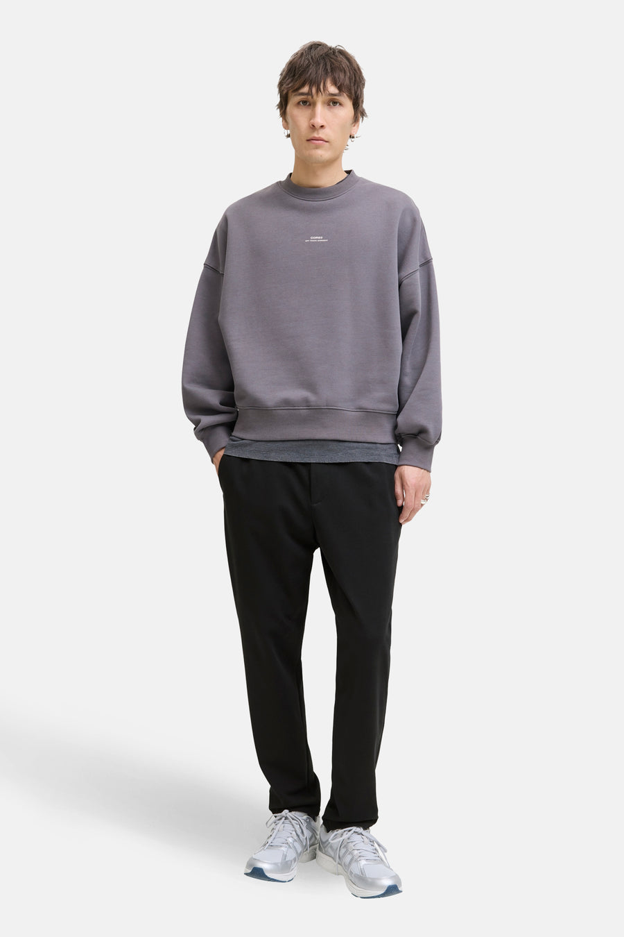 Pantalon noir de JACK & JONES JEANS INTELLIGENCE, combiné avec un pull gris et des baskets blanches.