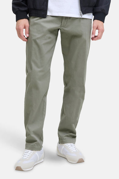 Pantalon de jogging Kaki de JACK & JONES JEANS INTELLIGENCE, associé à des baskets blanches et un manteau noir.