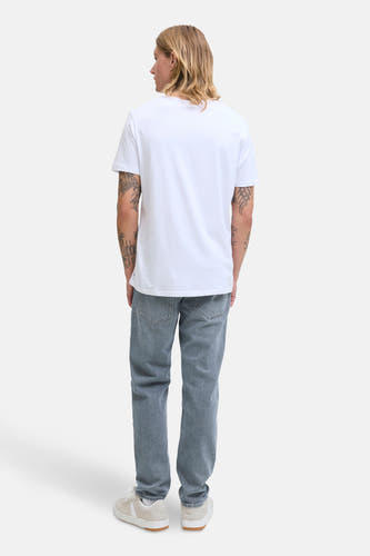 Jean tapered gris clair de JACK & JONES JEANS INTELLIGENCE, associé à un T-shirt blanc et des baskets crème.
