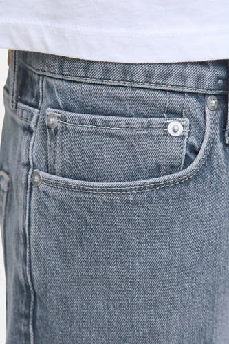 Jean tapered délavé clair de JACK & JONES JEANS INTELLIGENCE, avec petite poche et détail de bouton métallique.