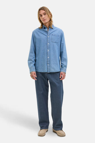 Jean large denim bleu foncé de JACK & JONES JEANS INTELLIGENCE, porté avec un chemisier denim et des chaussures en cuir de Suède.